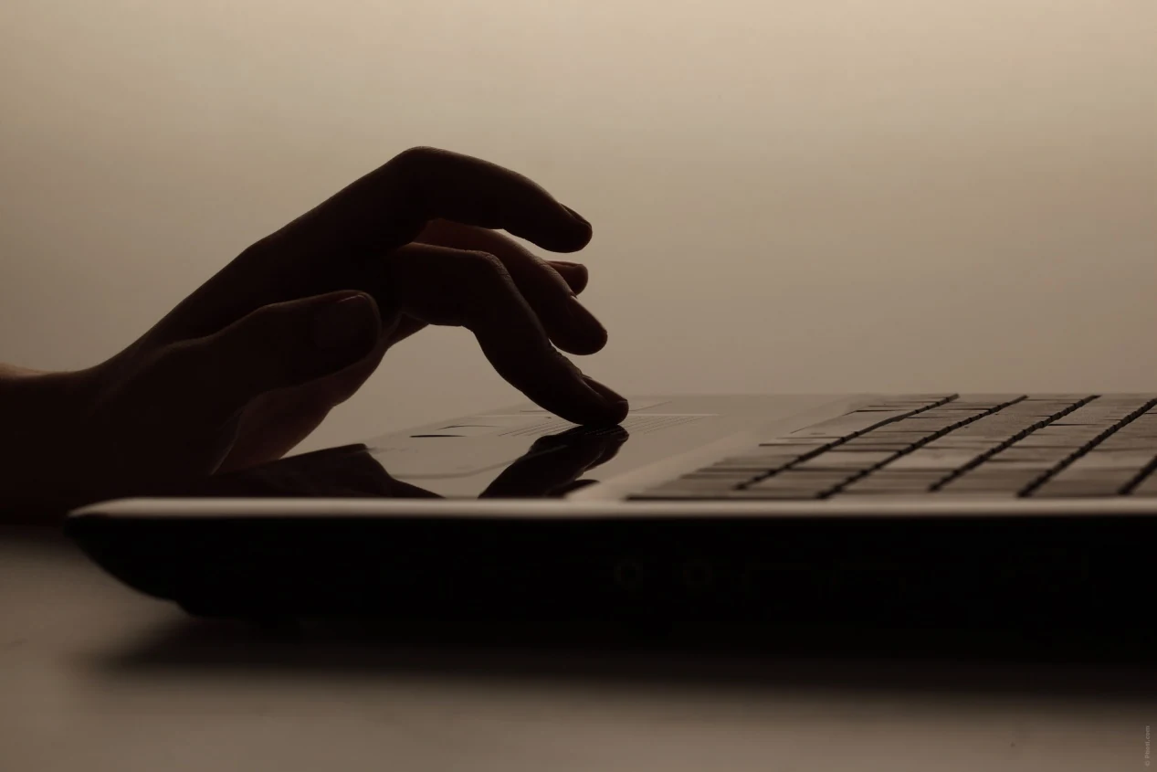 Main posée sur le clavier d'un ordinateur portable
